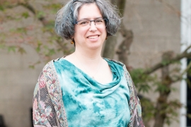 Fran Poodry seated and wearing a teal blouse